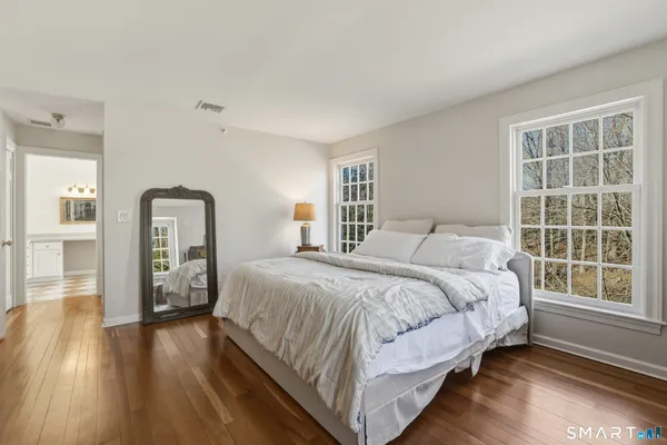 a bedroom with a bed and wooden floor