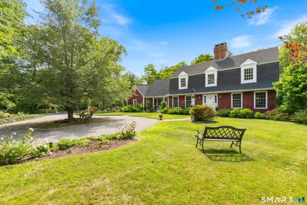 a view of a house with swimming pool lawn chairs and a yard