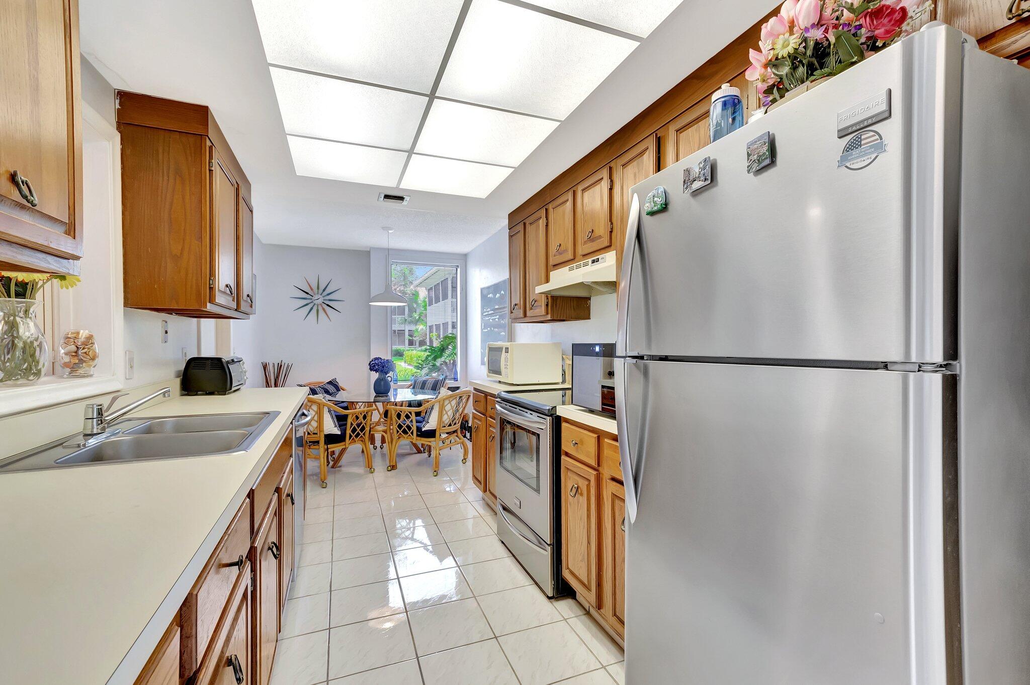 19819 Boca W Drive, Unit 4033 Boca Raton, FL 33434 - Photo 17 of 58 a kitchen with stainless steel appliances granite countertop a refrigerator and a sink
