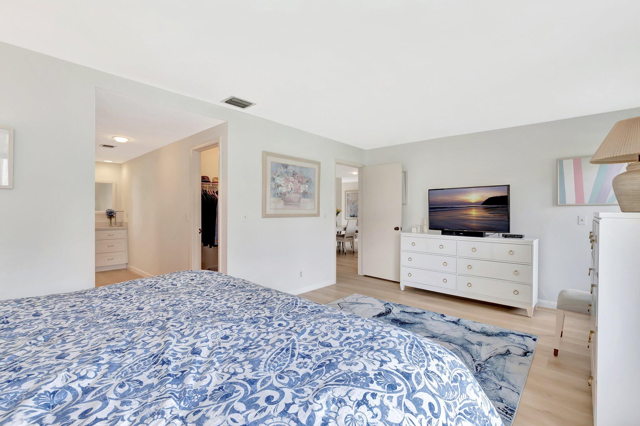 19819 Boca W Drive, Unit 4033 Boca Raton, FL 33434 - Photo 24 of 58 a bedroom with a bed and a television in it