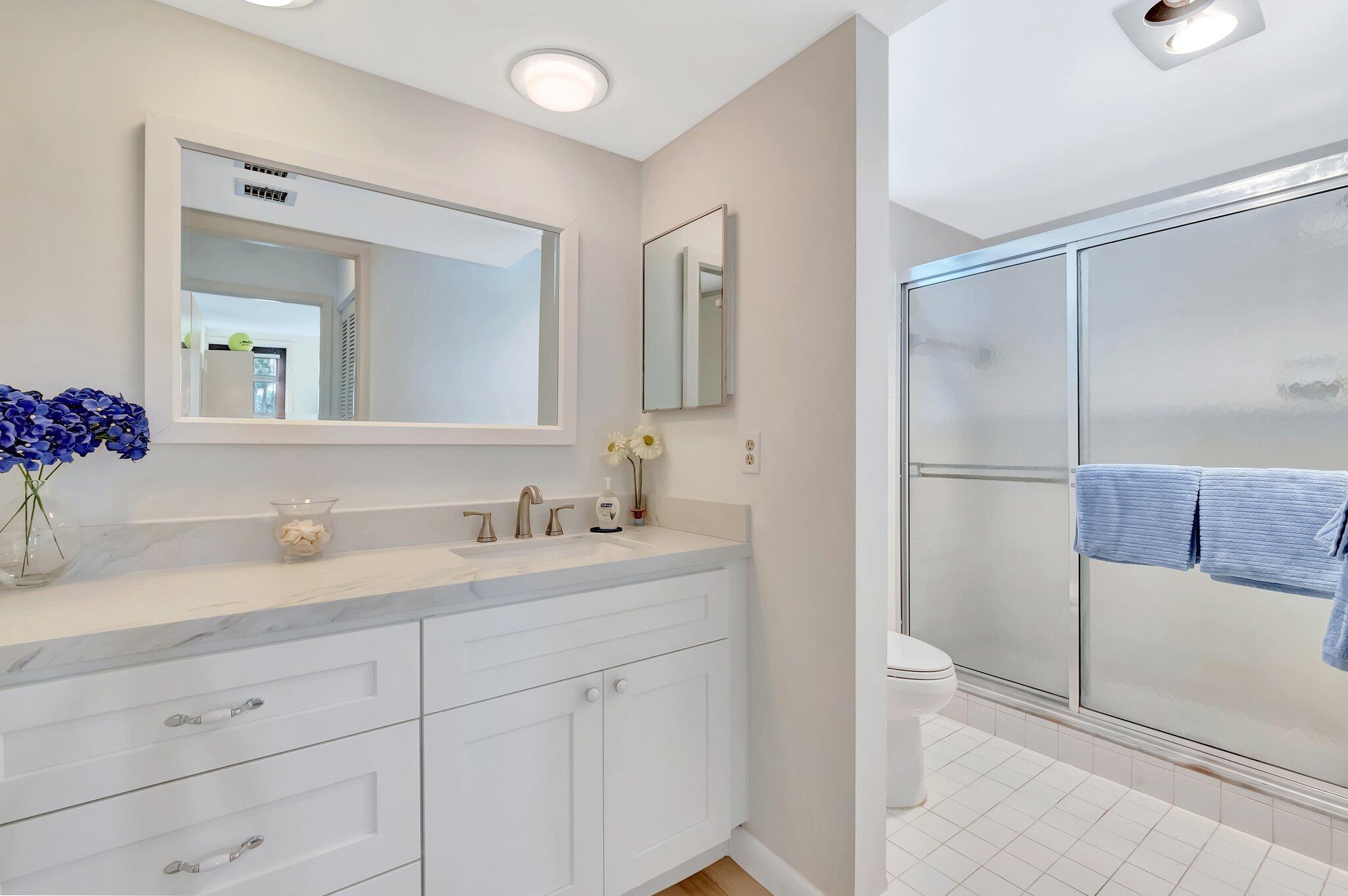 19819 Boca W Drive, Unit 4033 Boca Raton, FL 33434 - Photo 28 of 58 a en suite bathroom with a granite countertop sink and a mirror