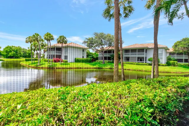 a view of a house with a big yard potted plants and a table and chair