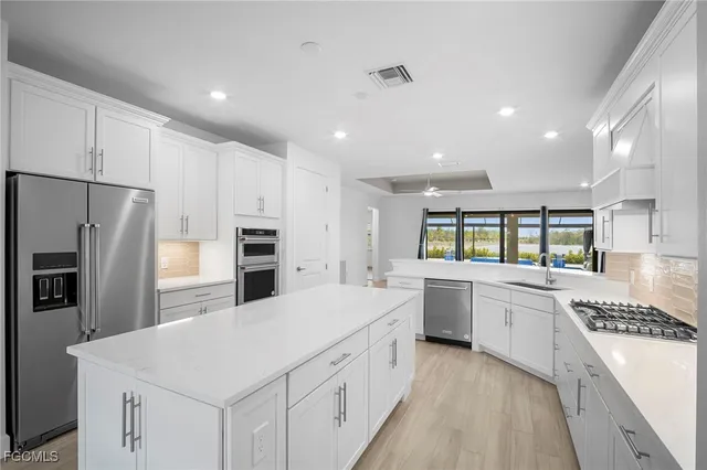 a large kitchen with a large counter top appliances and cabinets