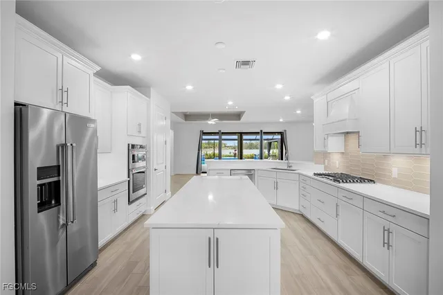 a kitchen with kitchen island white cabinets appliances and center island