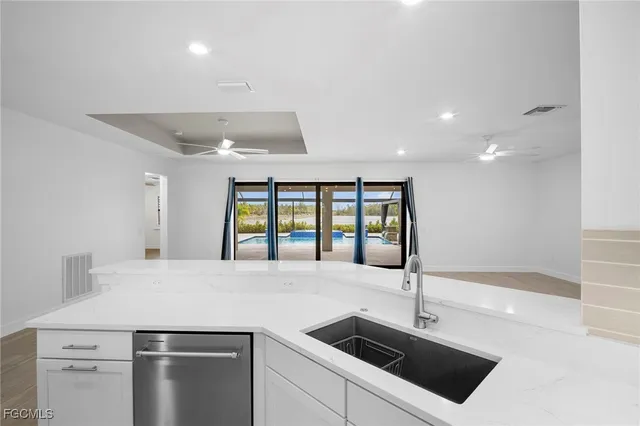 a kitchen with stainless steel appliances granite countertop a sink and a refrigerator