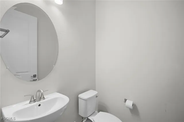 a bathroom with a toilet a sink and mirror