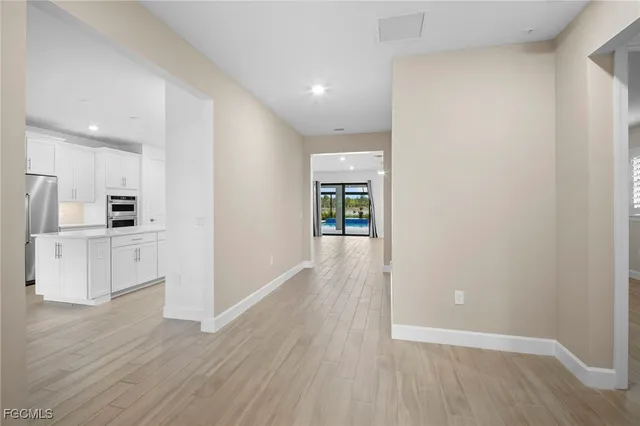 a view of a kitchen with wooden floor and a refrigerator