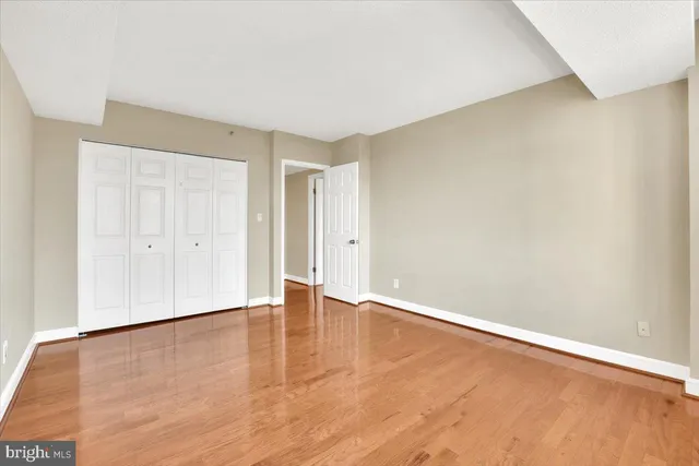 a view of an empty room with wooden floor