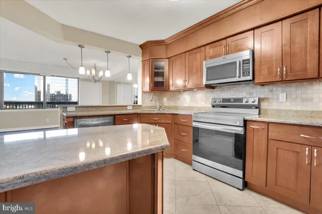 a kitchen with stainless steel appliances granite countertop a sink stove and microwave