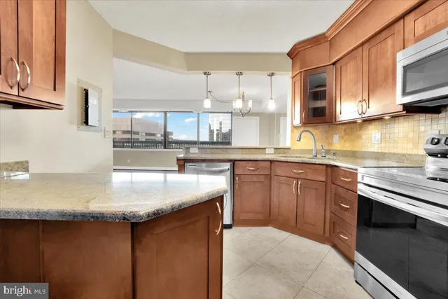 a kitchen with stainless steel appliances granite countertop a sink stove and microwave
