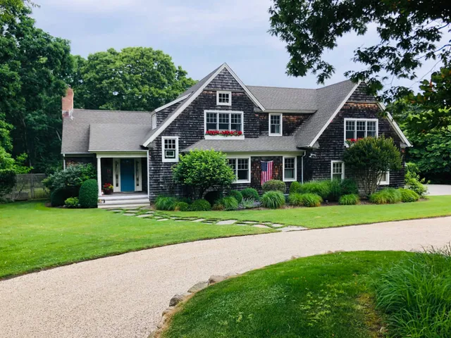 a front view of a house with a yard and trees