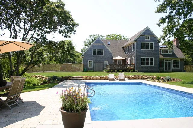 a front view of a house with swimming pool having outdoor seating