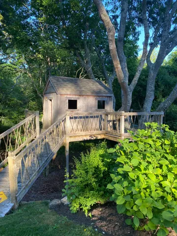 a view of house with a yard and deck