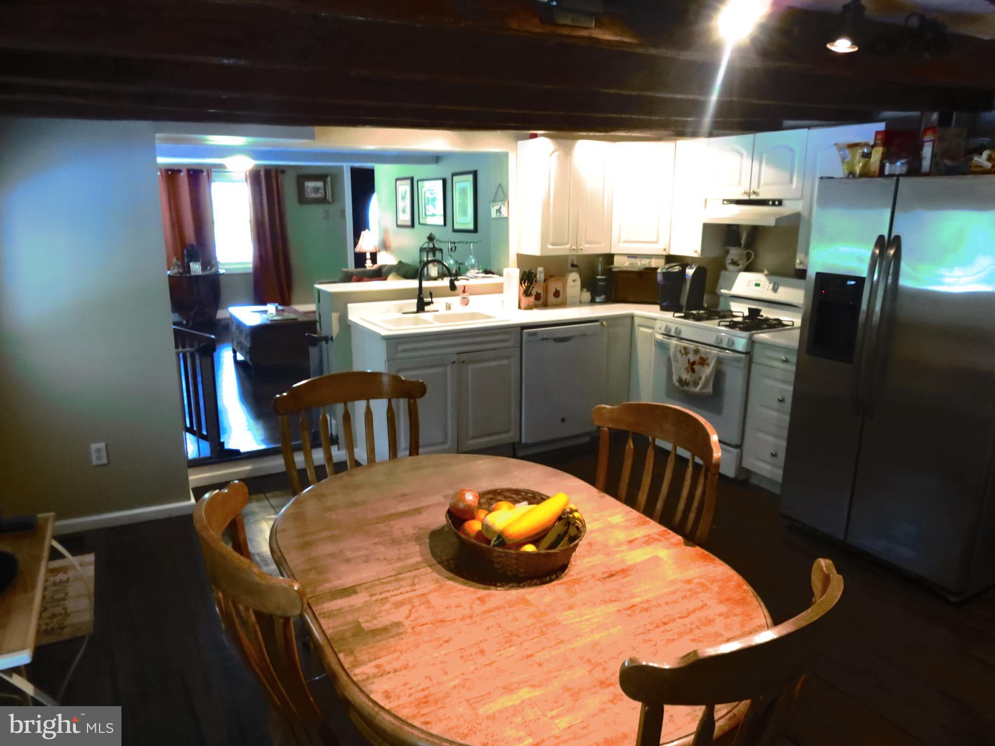 4166 Middleburg Road Union Bridge, MD 21791 - Photo 8 of 29 a kitchen with stainless steel appliances kitchen island granite countertop a sink a microwave dining table and chairs