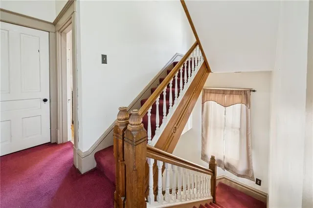a view of staircase with wooden floor and white walls
