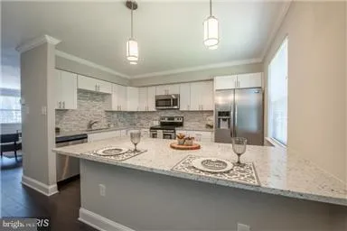 a kitchen with stainless steel appliances granite countertop a sink refrigerator and cabinets