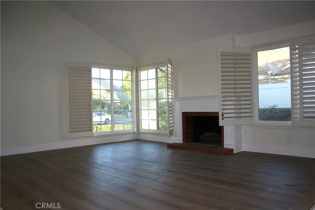 wooden floor fireplace and windows in an empty room