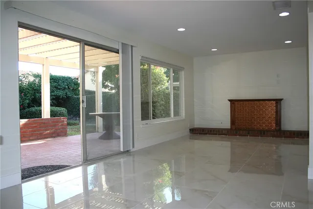 a view of an empty room with wooden floor and a fireplace
