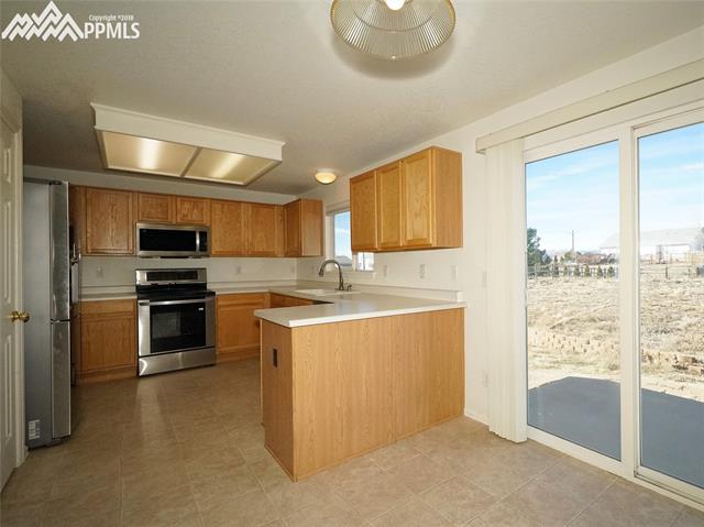 8572 Tibbs Road Peyton, CO 80831 - Photo 4 of 20 Eat-in kitchen with pantry and walk-out.