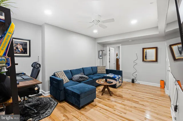 a living room with furniture a wooden floor and a bookshelf