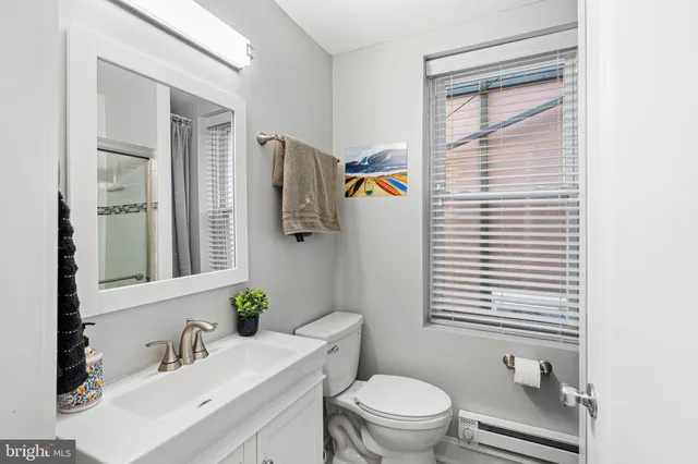a bathroom with a sink a toilet and mirror
