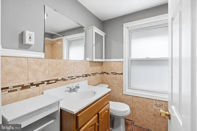 a view of a hallway with wooden floor and a bathroom