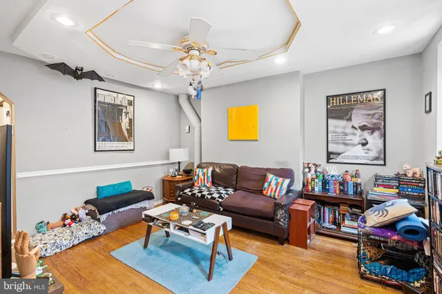 a living room with furniture and paintings on the wall
