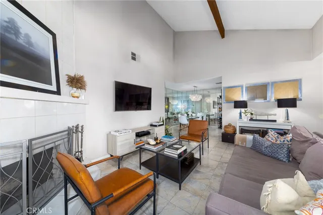 a living room with furniture kitchen view and a flat screen tv