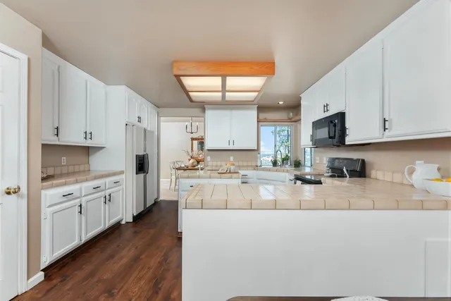a dining room with wooden floor a chandelier a wooden table and chairs