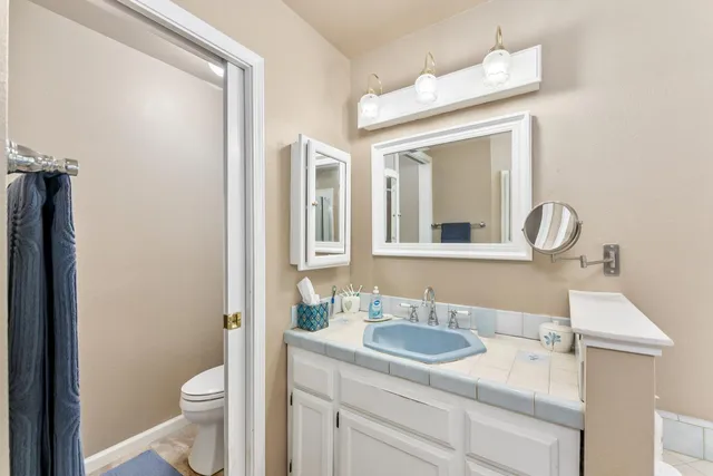 a bathroom with a toilet a sink and a mirror