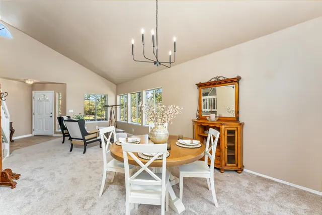 a dining room with furniture a chandelier and window