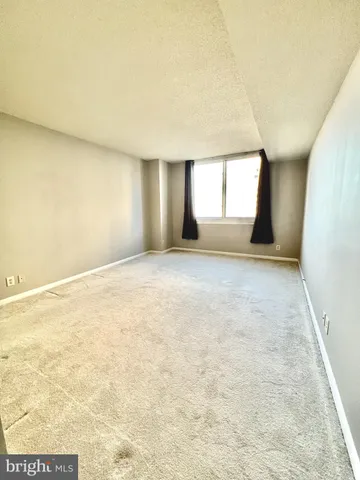 an empty room with closet and a ceiling fan