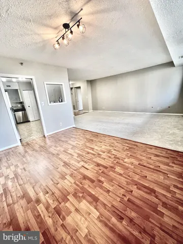 a view of a livingroom with wooden floor and ceiling fan