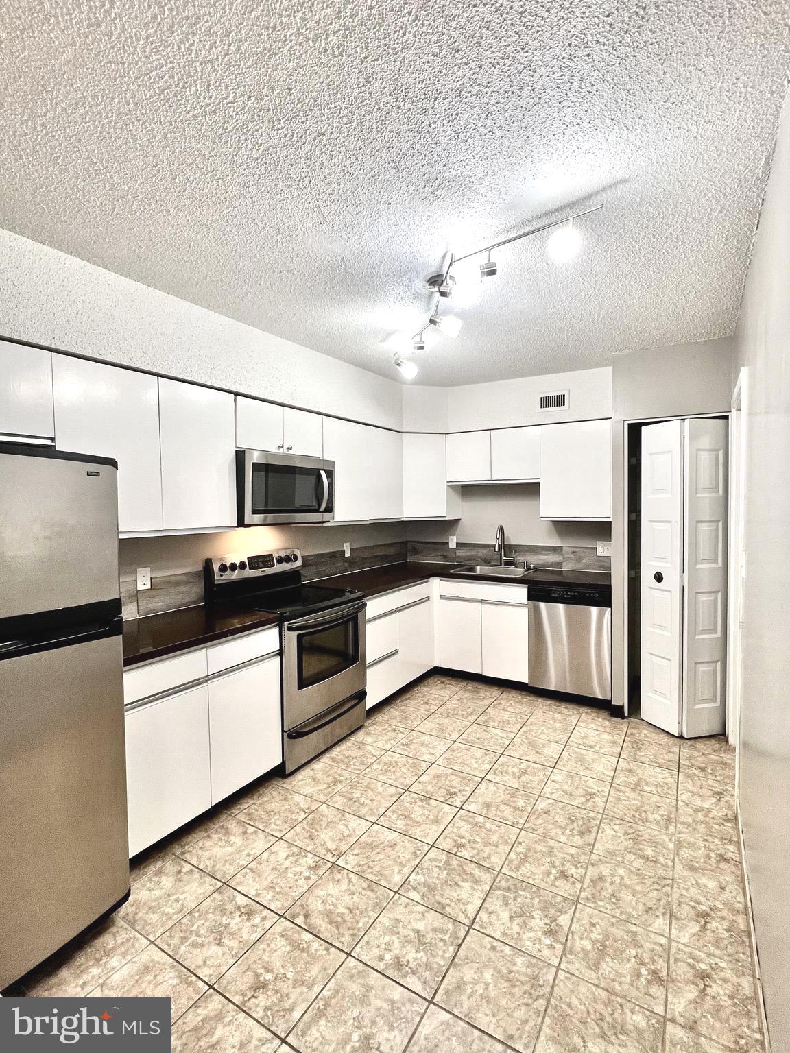 5501 Seminary Road, Unit 913S Falls Church, VA 22041 - Photo 5 of 28 a kitchen with stainless steel appliances kitchen island granite countertop a refrigerator and a stove top oven
