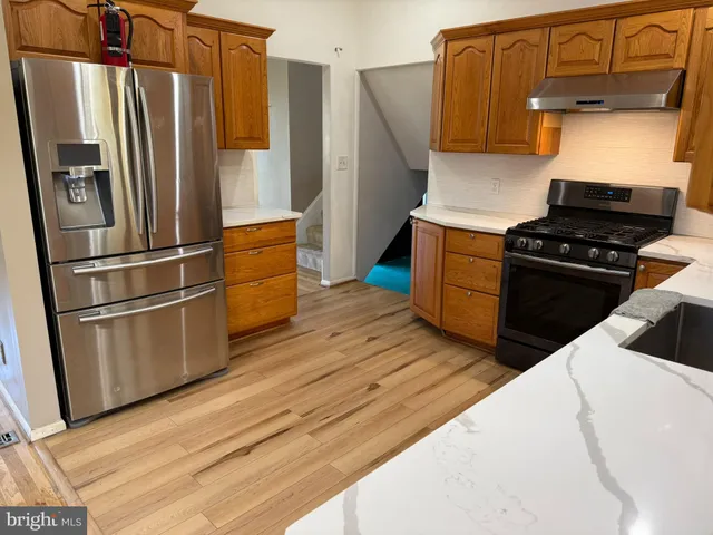 a kitchen with wooden floors and appliances