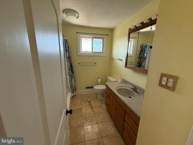 a bathroom with a sink a toilet a mirror and vanity