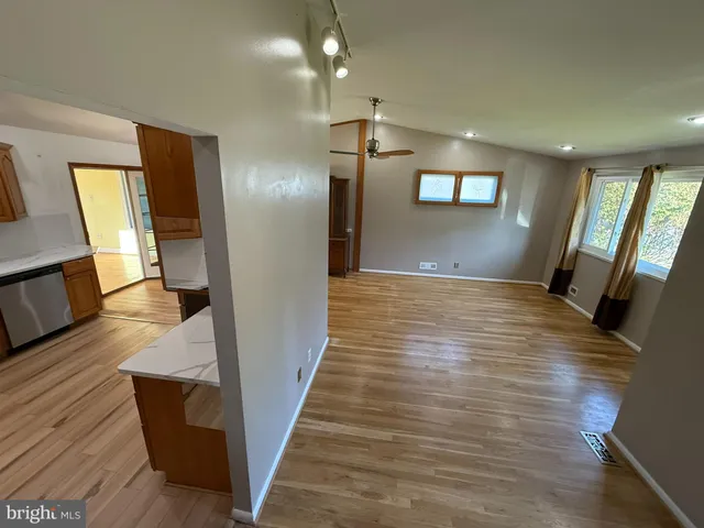 a view of a hallway with wooden floor and staircase