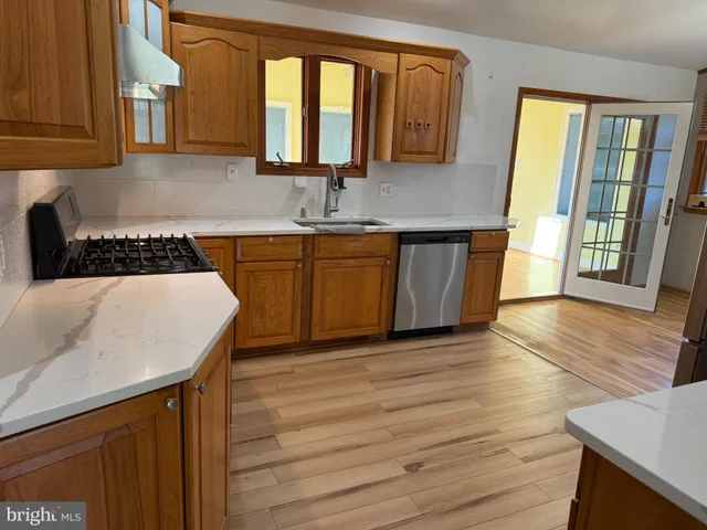 a kitchen with wooden floors wooden cabinets and sink