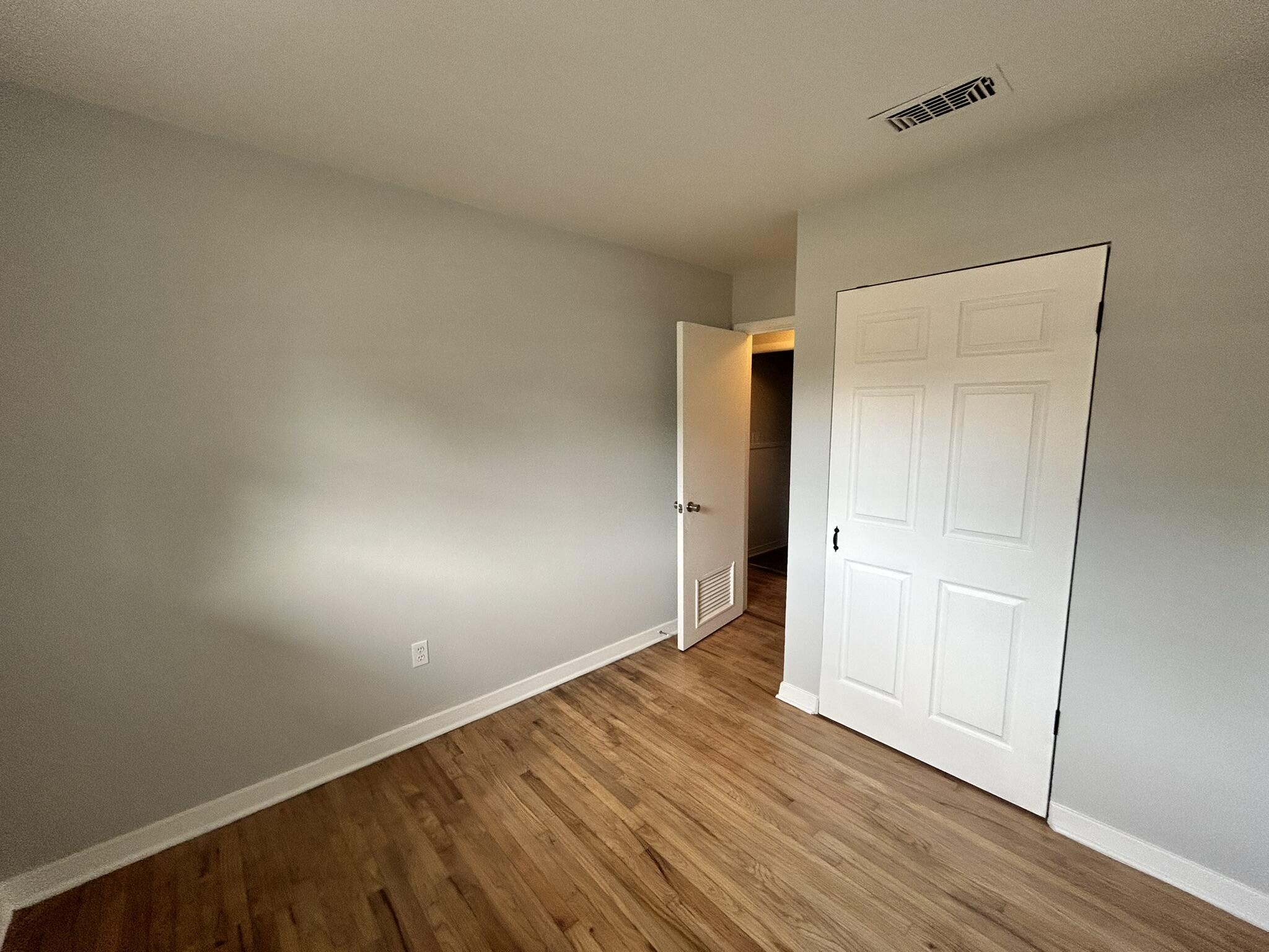 553 Purl Adams Avenue Crestview, FL 32539 - Photo 10 of 13 an empty room with wooden floor and windows