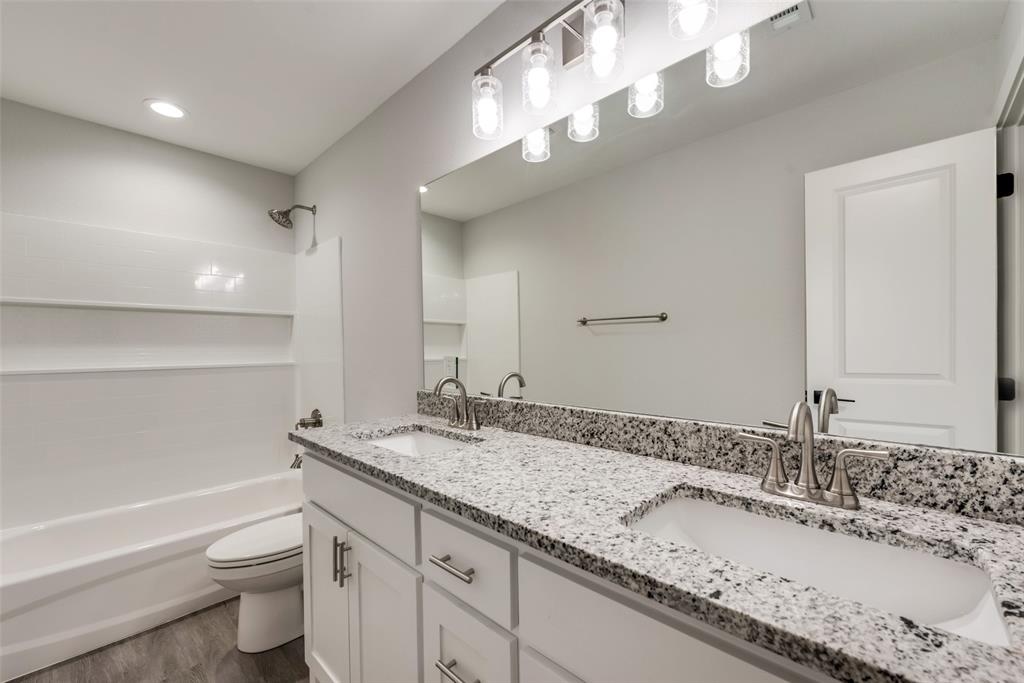 420 East 5th Street Bonham, TX 75418 - Photo 11 of 16 a bathroom with a granite countertop double vanity sink and a mirror
