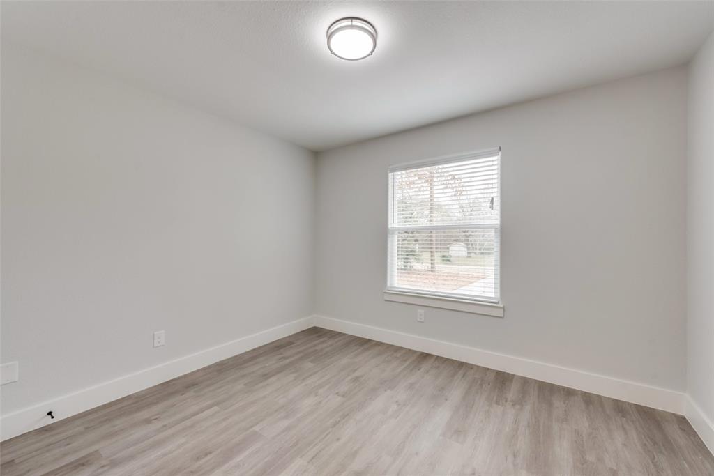 420 East 5th Street Bonham, TX 75418 - Photo 13 of 16 an empty room with wooden floor and windows