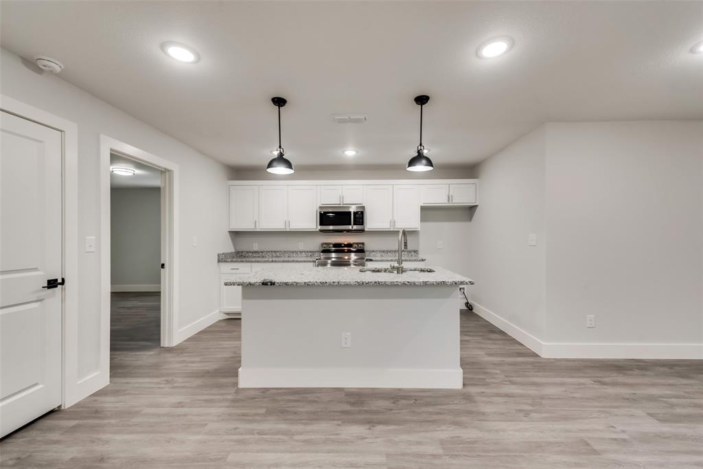 420 East 5th Street Bonham, TX 75418 - Photo 4 of 16 a large kitchen with stainless steel appliances granite countertop a stove and a refrigerator