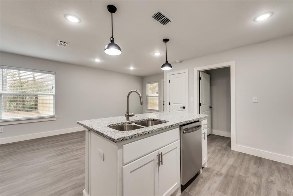 420 East 5th Street Bonham, TX 75418 - Photo 6 of 16 a kitchen with stainless steel appliances granite countertop a sink a window and wooden floor