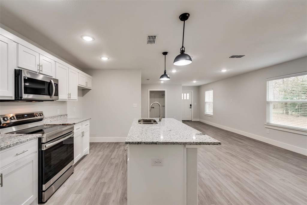 420 East 5th Street Bonham, TX 75418 - Photo 7 of 16 a kitchen with stove a sink and a refrigerator