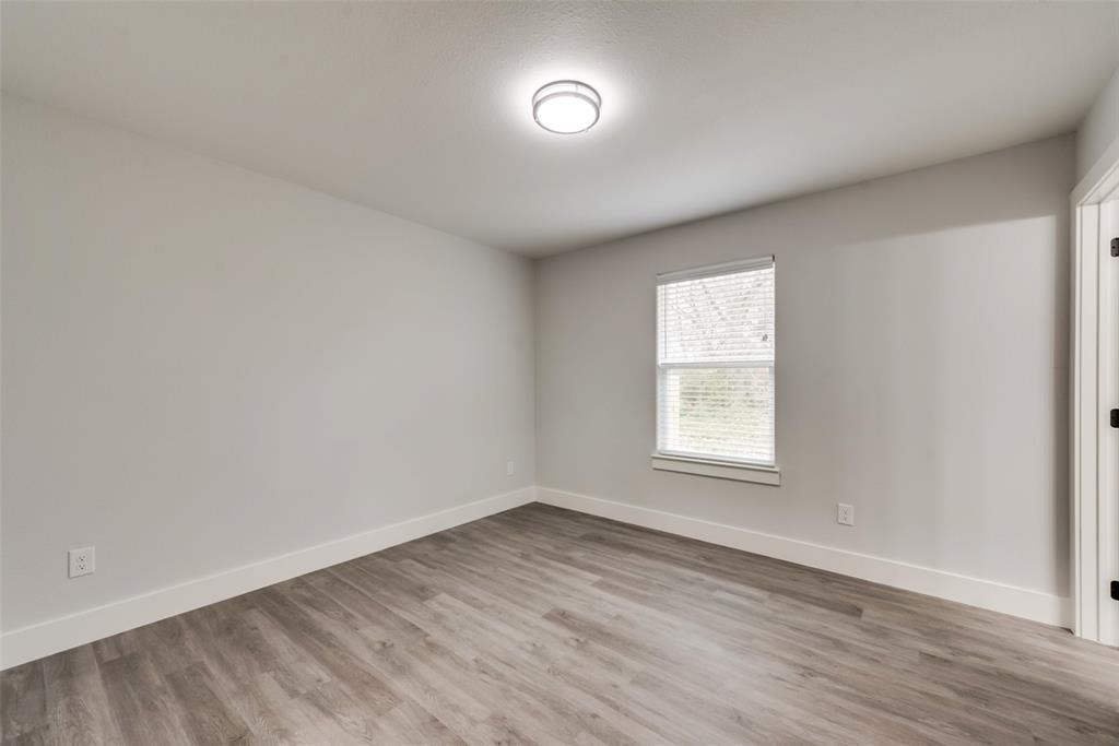 420 East 5th Street Bonham, TX 75418 - Photo 8 of 16 an empty room with wooden floor and windows