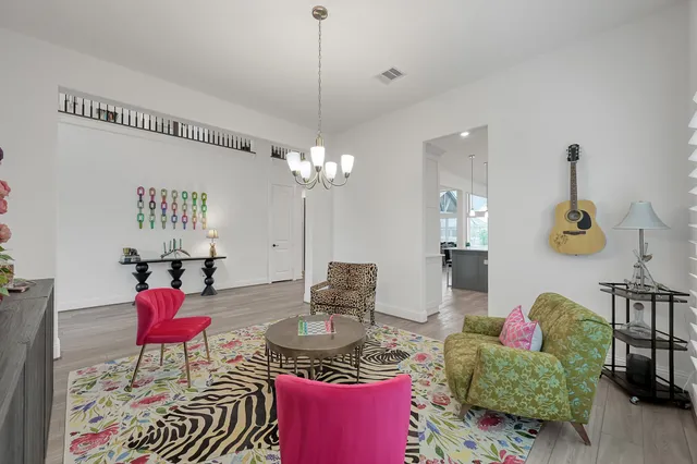 a living room with furniture and a chandelier