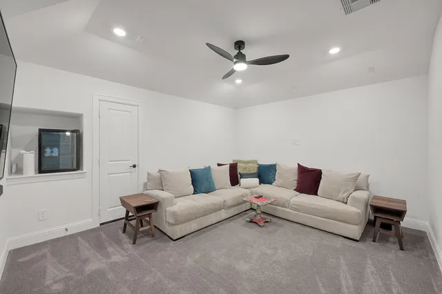 a living room with furniture and a ceiling fan