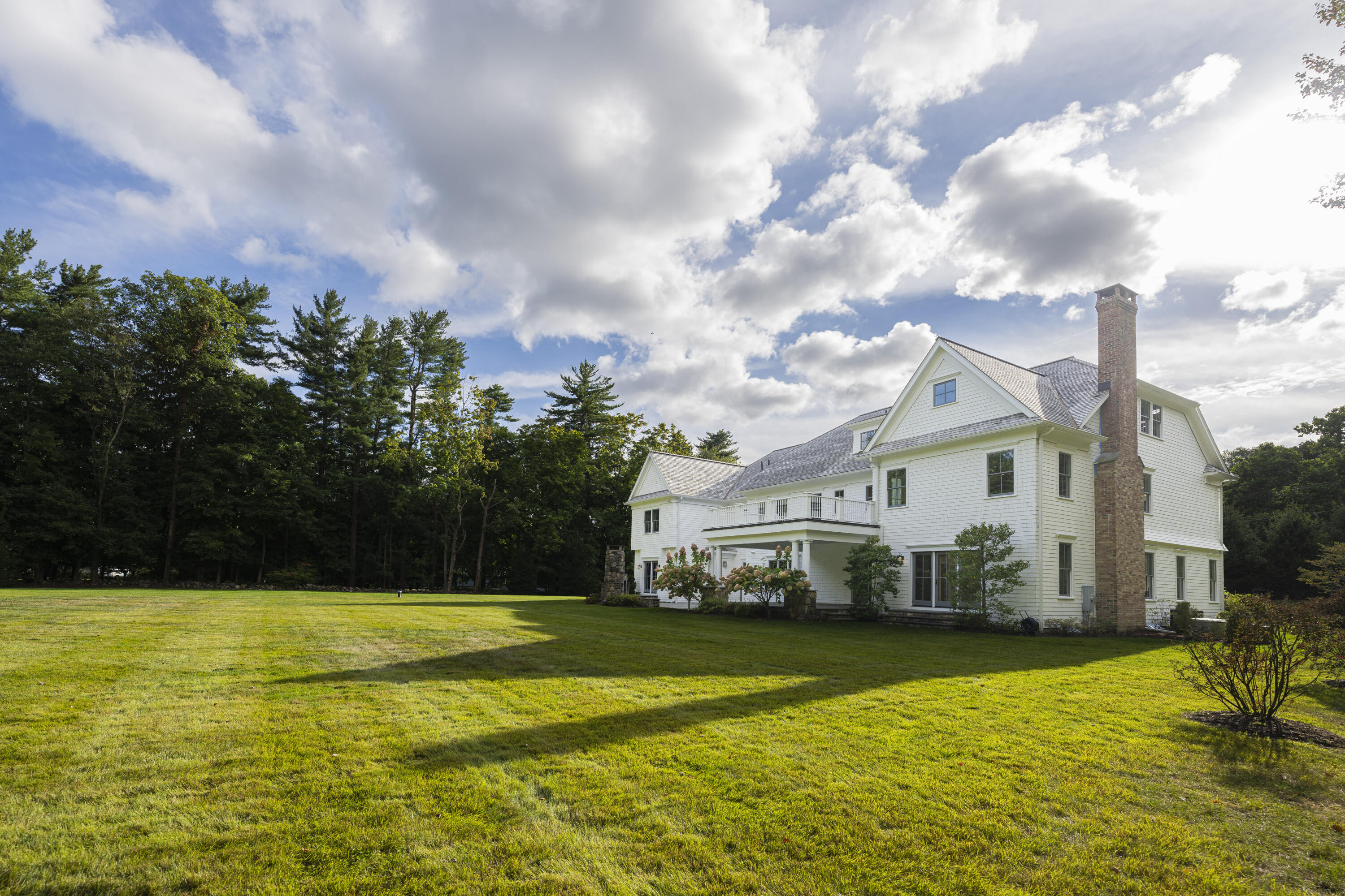 375 West Road New Canaan, CT 06840 - Photo 25 of 26 a view of a white house with a swimming pool and sitting area