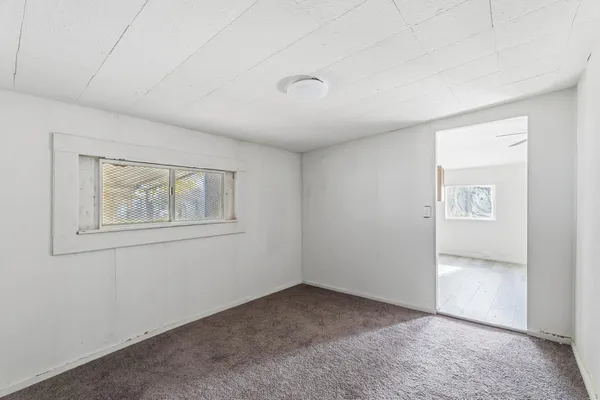 an empty room with windows and closet