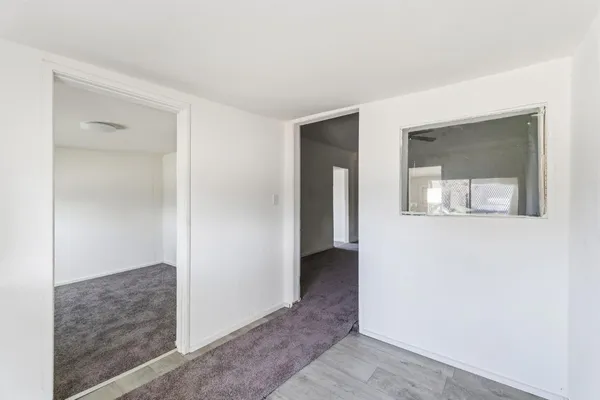 a hallway with two mirrors and a microwave